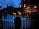 Night view of a fenced-in backyard pool with colorful umbrellas and house visible in the background at 424 Lake Point Trce, Canton, GA 30114