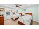 Bright bedroom showcasing two twin beds with floral bedding, a ceiling fan, and natural light from the window at 424 Lake Point Trce, Canton, GA 30114