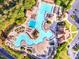 Aerial view of a luxurious community pool area with multiple pools, slides, and ample seating surrounded by lush landscaping at 424 Lake Point Trce, Canton, GA 30114