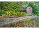Community sign featuring the name 'BridgeMill' with lush landscaping and a decorative water wheel feature at 424 Lake Point Trce, Canton, GA 30114