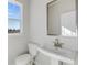 Small bathroom with toilet, sink, and a window at 214 Wilder Ridge Way, Lawrenceville, GA 30044