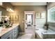 Bathroom featuring double vanity, grey cabinets, and a soaking tub with a window at 723 Crossroad Ct, Powder Springs, GA 30127