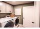Well-lit laundry room featuring a modern washer and dryer and ample storage space at 723 Crossroad Ct, Powder Springs, GA 30127