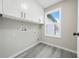 Laundry room with white cabinets and vinyl flooring at 4352 Riverlake Way, Snellville, GA 30039