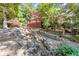 Picturesque backyard featuring a charming deck area, a cascading rock stream and beautiful foliage at 7300 Chattahoochee Bluff Dr, Atlanta, GA 30350