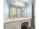 Bathroom vanity area with marble counters, storage drawers, and a large framed mirror reflecting the doorway and toilet at 7300 Chattahoochee Bluff Dr, Atlanta, GA 30350
