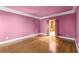 Spacious bedroom with hardwood floors, ample natural light, and doorway to an attached room with shelving at 7300 Chattahoochee Bluff Dr, Atlanta, GA 30350