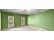 Green bedroom featuring two windows with blinds, plush carpeting, and neutral trim at 7300 Chattahoochee Bluff Dr, Atlanta, GA 30350