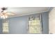 Bedroom with blue walls, crown molding, a ceiling fan, and two large windows bringing in natural light at 7300 Chattahoochee Bluff Dr, Atlanta, GA 30350
