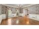 Formal dining room with decorative wallpaper, classic trim, and large windows providing ample natural light at 7300 Chattahoochee Bluff Dr, Atlanta, GA 30350
