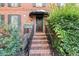 Inviting front porch with brick steps, black iron railings, and a charming awning over the wood door at 7300 Chattahoochee Bluff Dr, Atlanta, GA 30350