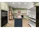 Bright kitchen featuring an island, stainless appliances, tile floor, and custom cabinetry at 7300 Chattahoochee Bluff Dr, Atlanta, GA 30350