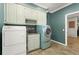 Well-lit laundry room with washer, dryer, utility sink, and custom cabinet storage at 7300 Chattahoochee Bluff Dr, Atlanta, GA 30350