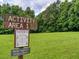 Park activity area with a grassy field, trees and a sign at 701 Trevett Way, Marietta, GA 30062