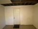 Unfinished basement with carpet flooring, painted walls, and utility door at 2787 Heritage Ln, Morrow, GA 30260