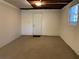 Unfinished basement space with carpet flooring, painted walls, and utility door at 2787 Heritage Ln, Morrow, GA 30260