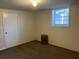 Carpeted basement featuring a utility door, single hung window, and dehumidifier at 2787 Heritage Ln, Morrow, GA 30260