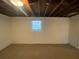 Unfinished basement featuring carpet flooring, painted walls, and single hung window at 2787 Heritage Ln, Morrow, GA 30260