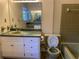 Vintage bathroom with single sink vanity, mirror, toilet, and tiled shower-tub combination at 2787 Heritage Ln, Morrow, GA 30260