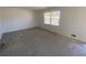 Cozy bedroom has large window that offers bright light and neutral carpeting and wall color at 2787 Heritage Ln, Morrow, GA 30260