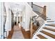 Inviting hallway with hardwood floors, decorative lighting, staircase, and large mirror, leading to an open living space at 729 Keystone Dr, Woodstock, GA 30188