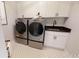 Laundry room featuring modern washer and dryer, stylish flooring, and ample storage at 729 Keystone Dr, Woodstock, GA 30188