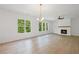 Bright living room featuring hardwood floors, a modern fireplace, and large windows offering a view of the trees at 729 Keystone Dr, Woodstock, GA 30188