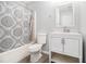 Clean bathroom with a shower/tub combo, toilet, vanity with a sink, a mirror, and an included bathmat at 6427 Grey Fox Way, Riverdale, GA 30296
