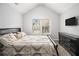 Cozy bedroom featuring neutral paint, a window, plush carpet, a TV, and a bed with stylish pillows and bedding at 6427 Grey Fox Way, Riverdale, GA 30296
