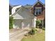 Charming townhouse with brick and siding, featuring a two-car garage and landscaped front yard at 183 Regent Pl, Woodstock, GA 30188