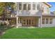 Rear view of a home with a covered patio and a lush green lawn surrounded by trees at 420 Argonne Nw Dr, Atlanta, GA 30305