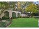 Well-manicured backyard with a white brick wall covered in vines and a lush lawn at 420 Argonne Nw Dr, Atlanta, GA 30305