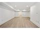 Large basement area with wood-look floors and white trim and walls leading to a pair of doors at 420 Argonne Nw Dr, Atlanta, GA 30305