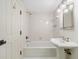 Bathroom with a pedestal sink, combined tub and shower with tile surround, and white painted door at 420 Argonne Nw Dr, Atlanta, GA 30305