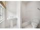Bright bathroom features a pedestal sink, and classic white subway tile in the shower and bath at 420 Argonne Nw Dr, Atlanta, GA 30305