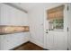 Mudroom with white cabinetry, sink, stone backsplash, and door to the exterior at 420 Argonne Nw Dr, Atlanta, GA 30305