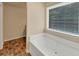 Bathroom featuring a large soaking tub by a bright window for relaxing baths and natural light at 363 Lobdale Falls Dr, Lawrenceville, GA 30045