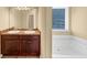 Bathroom vanity with double sinks, a large mirror, and a soaking tub that invite pampering and self-care at 363 Lobdale Falls Dr, Lawrenceville, GA 30045