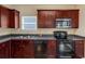 A kitchen featuring stainless steel appliances, wooden cabinets, and dark countertops at 363 Lobdale Falls Dr, Lawrenceville, GA 30045