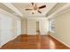 Spacious main bedroom with tray ceiling, hardwood floors, and multiple closets and doors for added function at 363 Lobdale Falls Dr, Lawrenceville, GA 30045