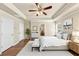 Staged main bedroom featuring hardwood floors, a decorative tray ceiling, and stylish decor for a cozy feel at 363 Lobdale Falls Dr, Lawrenceville, GA 30045