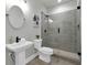 Modern bathroom with tiled walk-in shower, pedestal sink, and gray walls with decorative mirror at 3745 Pilgrim Mill Rd, Cumming, GA 30041
