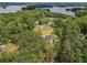 Aerial view showing the house, surrounding trees, and Lake Lanier in the distance at 3780 Tamiami Trl, Cumming, GA 30041