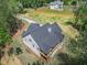 Stunning aerial view of a modern home with a wooded backyard and a sprawling lawn at 3780 Tamiami Trl, Cumming, GA 30041