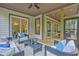 Covered porch featuring an outdoor living area with ceiling fan and views of a wooded area at 3780 Tamiami Trl, Cumming, GA 30041