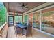 Covered back porch with wood flooring, ceiling fan, and a table with six chairs at 3780 Tamiami Trl, Cumming, GA 30041