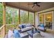 Screened-in porch with ceiling fan, outdoor furniture, and wood flooring with views of wooded area at 3780 Tamiami Trl, Cumming, GA 30041