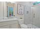 Bright bathroom with a walk-in shower, a window, and a vanity with a white countertop at 3780 Tamiami Trl, Cumming, GA 30041