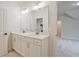 Elegant bathroom featuring double sinks, white cabinets, gold hardware, and large mirror at 3780 Tamiami Trl, Cumming, GA 30041