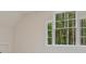 Bright bedroom featuring multi-pane windows showcasing lush greenery, filling the space with natural light at 3780 Tamiami Trl, Cumming, GA 30041